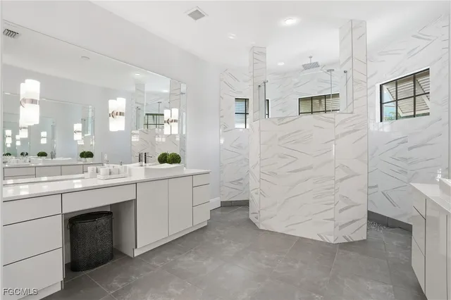 a bathroom with a double vanity sink a toilet a mirror and shower