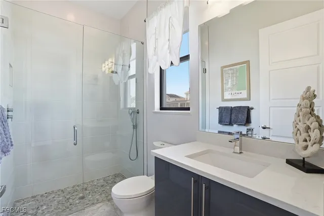 a bathroom with a sink toilet vanity and shower