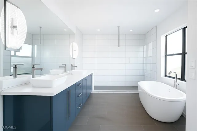 a bathroom with a double vanity sink a mirror and a bathtub