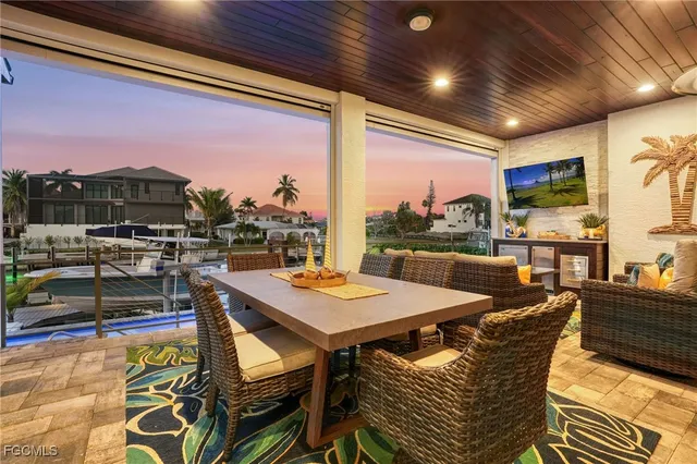 a view of a dining room with furniture one side kitchen view and wooden floor