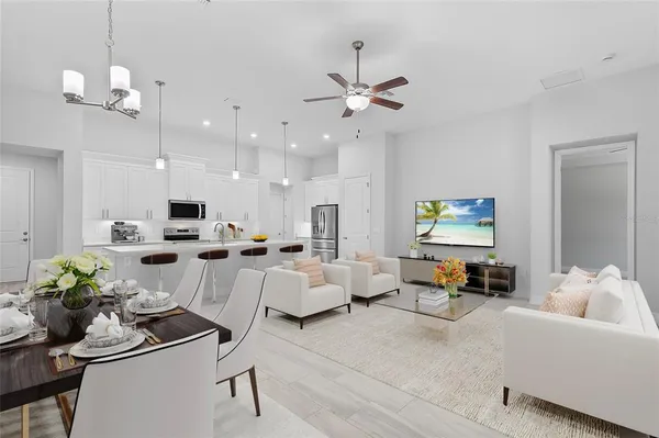 a living room with furniture kitchen view and a chandelier