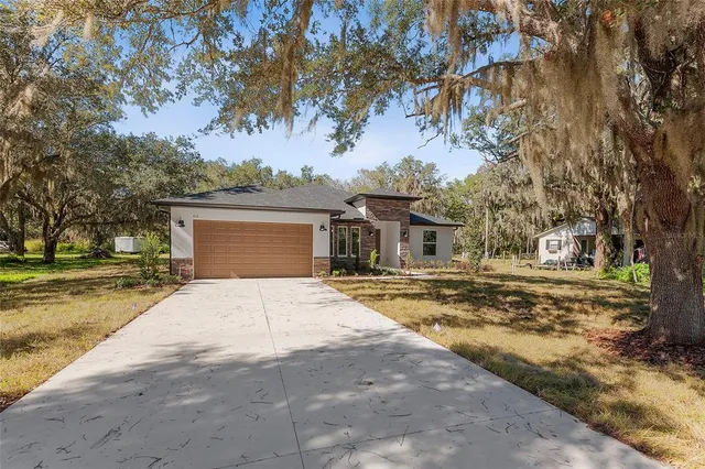 a front view of a house with a yard and trees