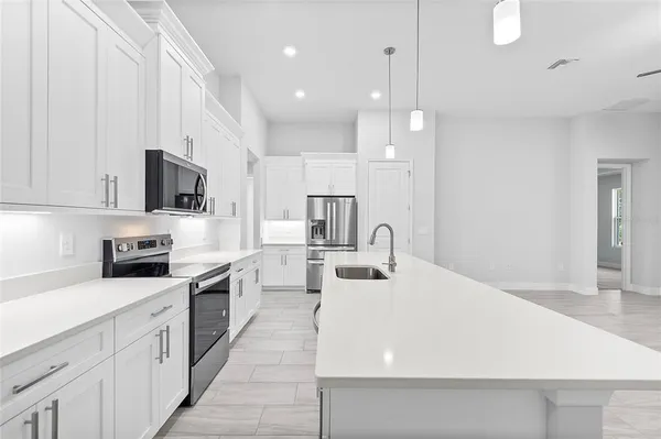 a kitchen with kitchen island a sink stainless steel appliances and cabinets