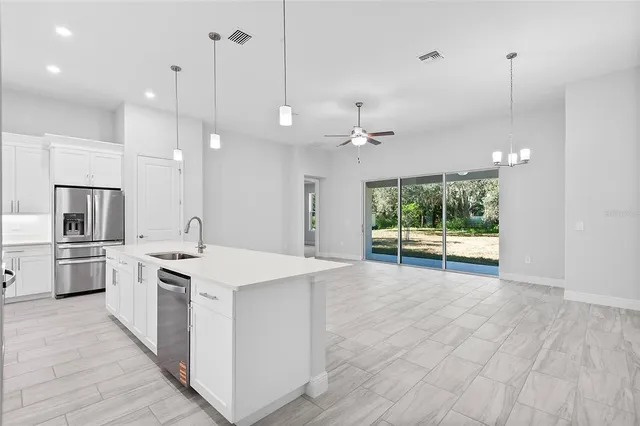 a kitchen with kitchen island a stove a sink a center island and a wooden floor