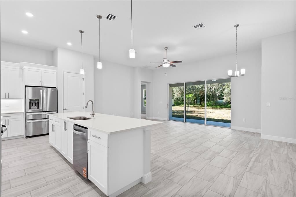 304 North Jungle Road Geneva, FL 32732 - Photo 11 of 49 a kitchen with kitchen island a stove a sink a center island and a wooden floor