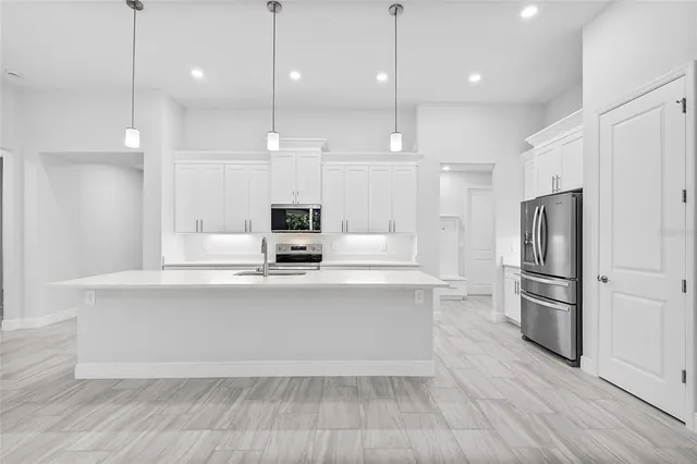 a large kitchen with cabinets and stainless steel appliances