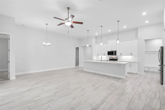 a view of kitchen with kitchen island white cabinets and stainless steel appliances
