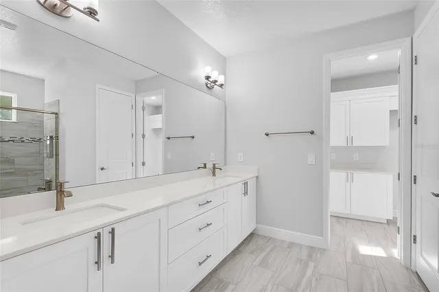 a spacious bathroom with a shower sink and mirror