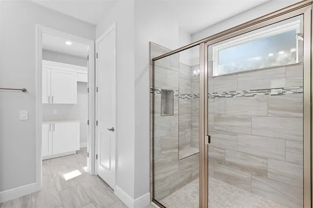 a bathroom with a glass shower door and mirror