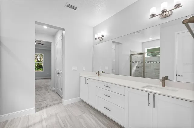 a spacious bathroom with double sink and a mirror