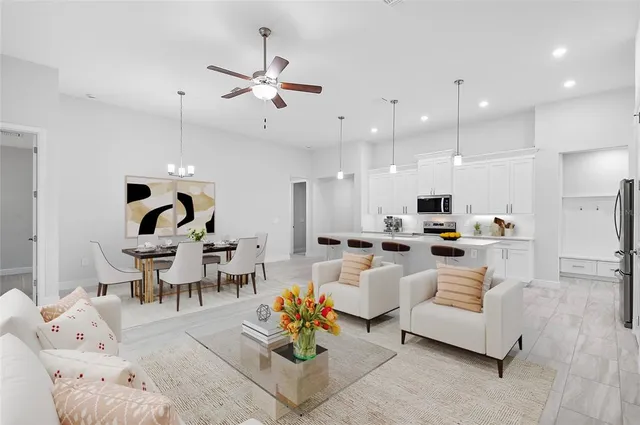 a living room with furniture kitchen view and a chandelier