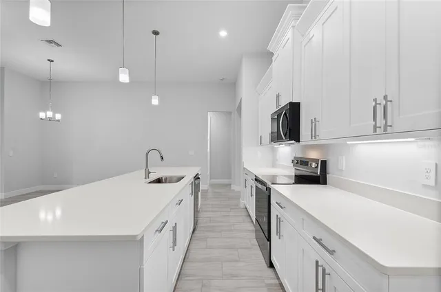 a kitchen with a sink stove and microwave