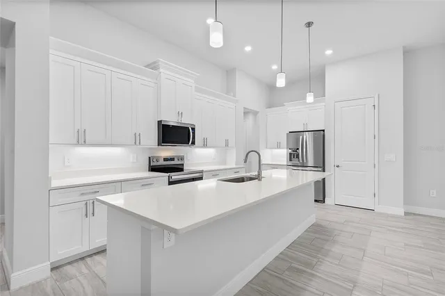 a kitchen with stainless steel appliances a sink stove and refrigerator