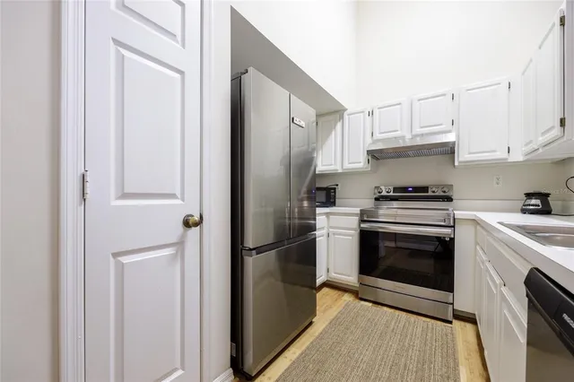 a kitchen with stainless steel appliances granite countertop a refrigerator stove and sink