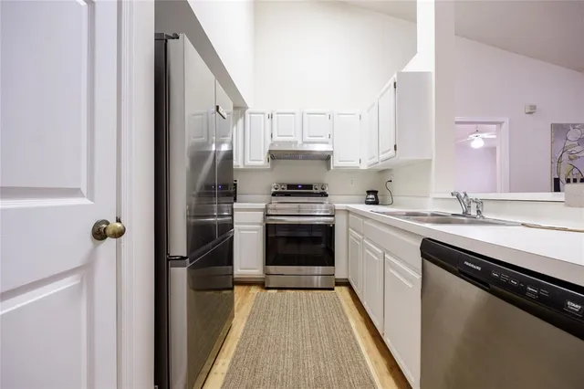 a kitchen with stainless steel appliances a stove sink and refrigerator