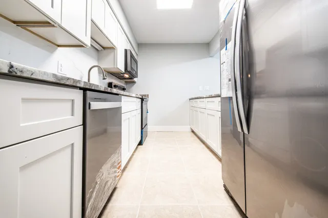a kitchen with granite countertop stainless steel appliances and sink