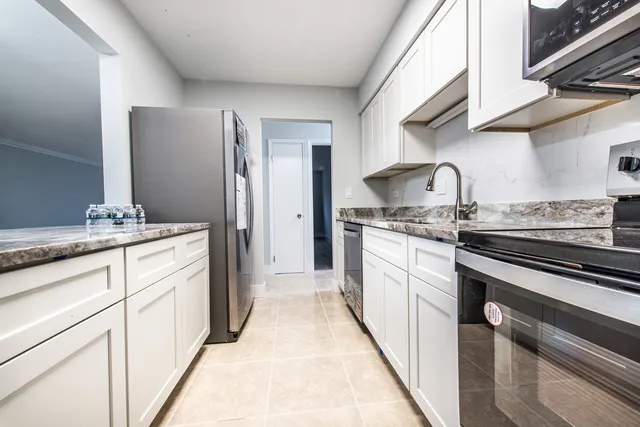 a kitchen with stainless steel appliances granite countertop a stove and a microwave