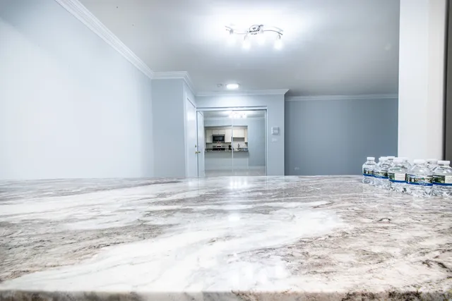 a view of a livingroom with wooden floor and kitchen space