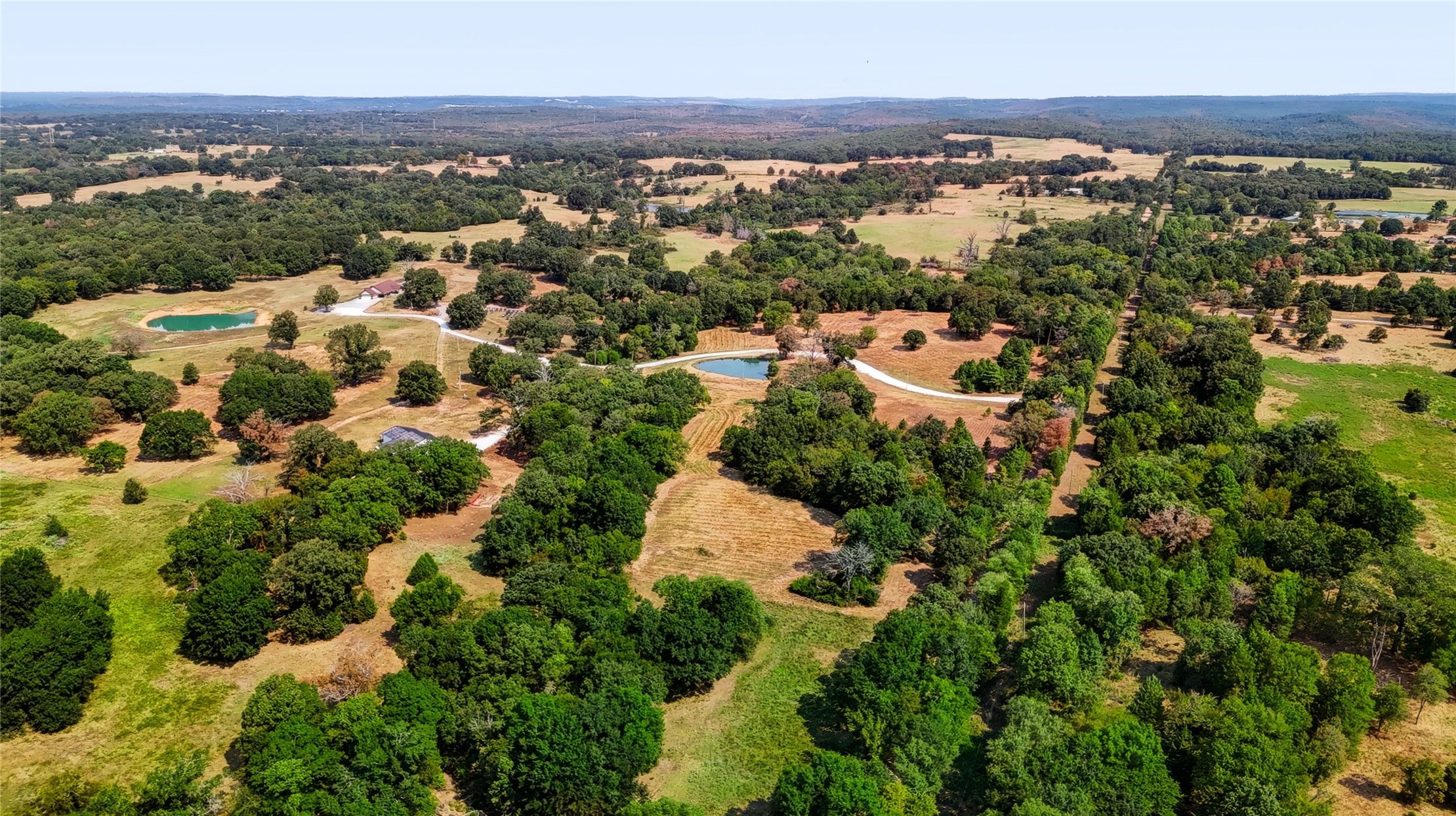 3607 South Half Bank Road Atoka, OK 74525 - Photo 79 of 82 Expansive land featuring mature trees, two visible ponds, and a winding driveway