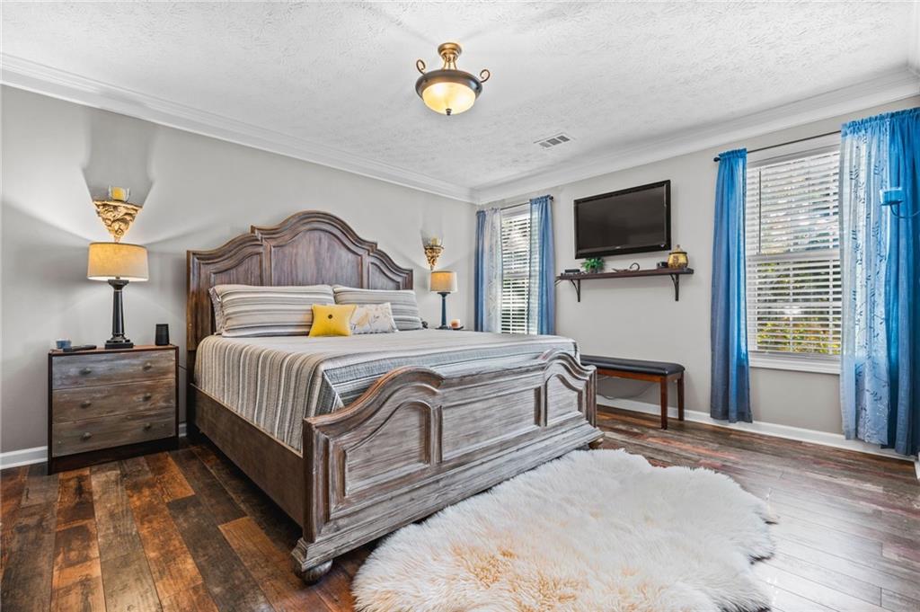 202 Weatherstone Crossing Woodstock, GA 30188 - Photo 16 of 29 a bedroom with a bed a flat screen tv and a chandelier