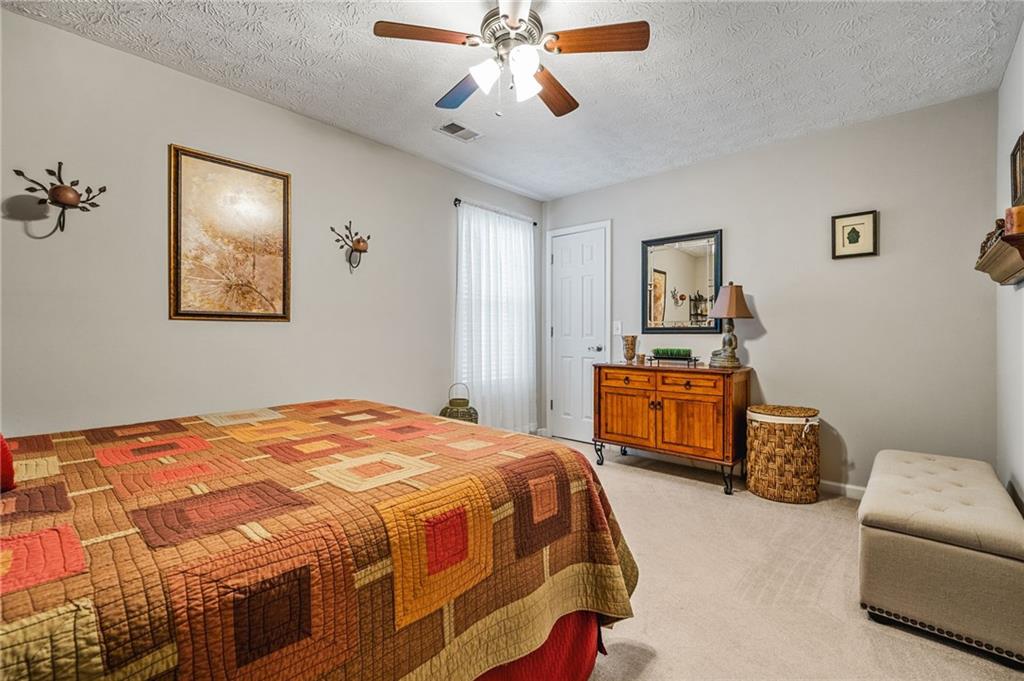202 Weatherstone Crossing Woodstock, GA 30188 - Photo 25 of 29 a bedroom with a bed and a chandelier