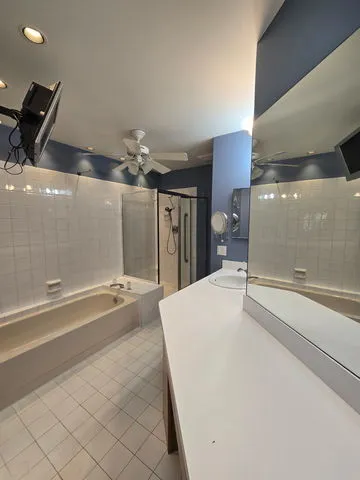 a spacious bathroom with a tub and mirror