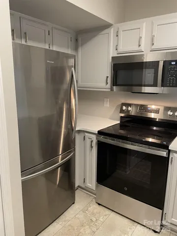 a metallic refrigerator freezer sitting inside of a kitchen