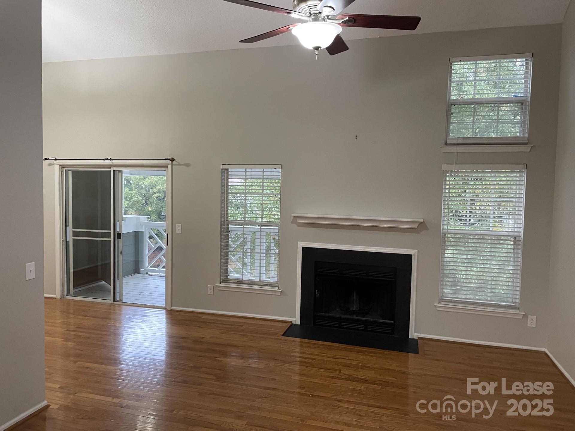 19831 Henderson Road, Unit E Cornelius, NC 28031 - Photo 4 of 23 a view of an empty room with wooden floor fireplace and a window