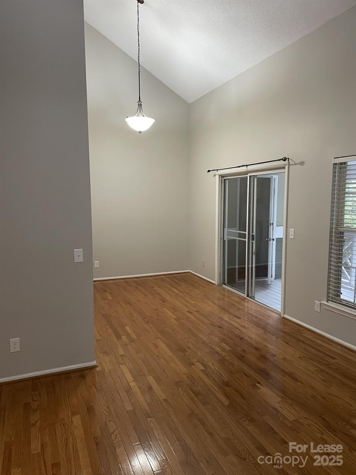 19831 Henderson Road, Unit E Cornelius, NC 28031 - Photo 5 of 23 a view of an empty room with wooden floor and fan