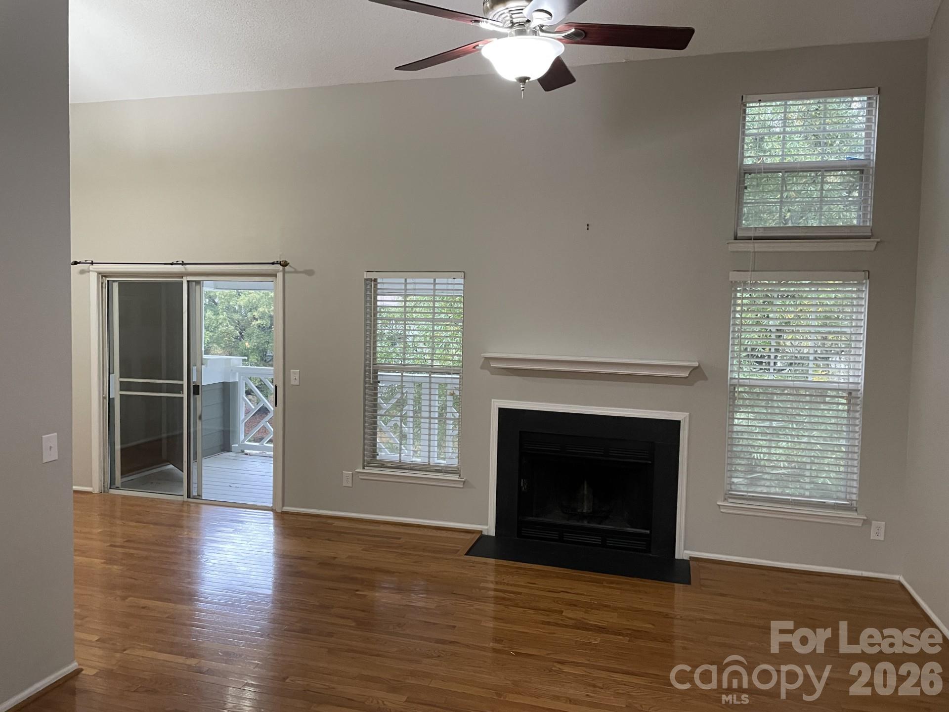 19831 Henderson Road, Unit E Cornelius, NC 28031 - Photo 6 of 27 a view of an empty room with wooden floor fireplace and a window
