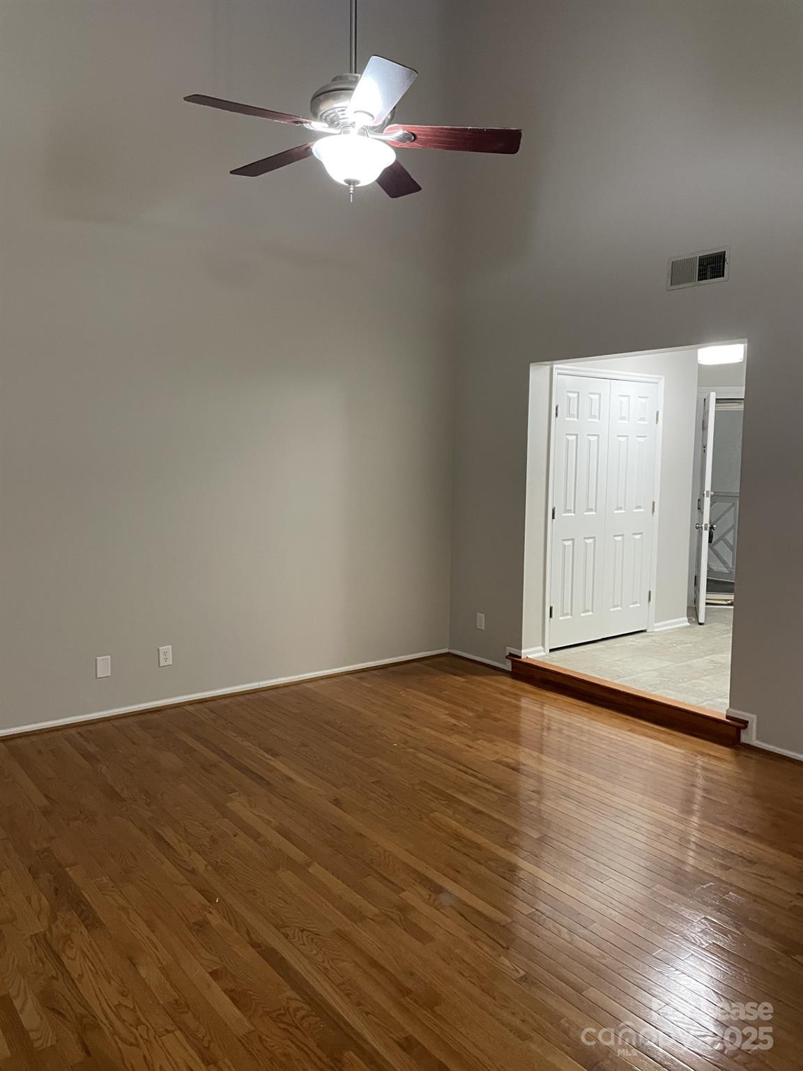 19831 Henderson Road, Unit E Cornelius, NC 28031 - Photo 8 of 23 a view of an empty room with wooden floor and a window