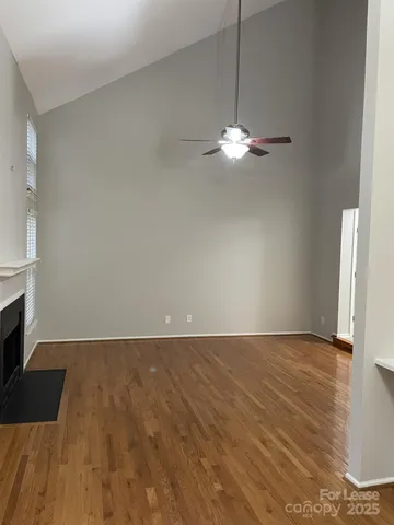a view of a livingroom with a ceiling fan wooden floor and a ceiling fan