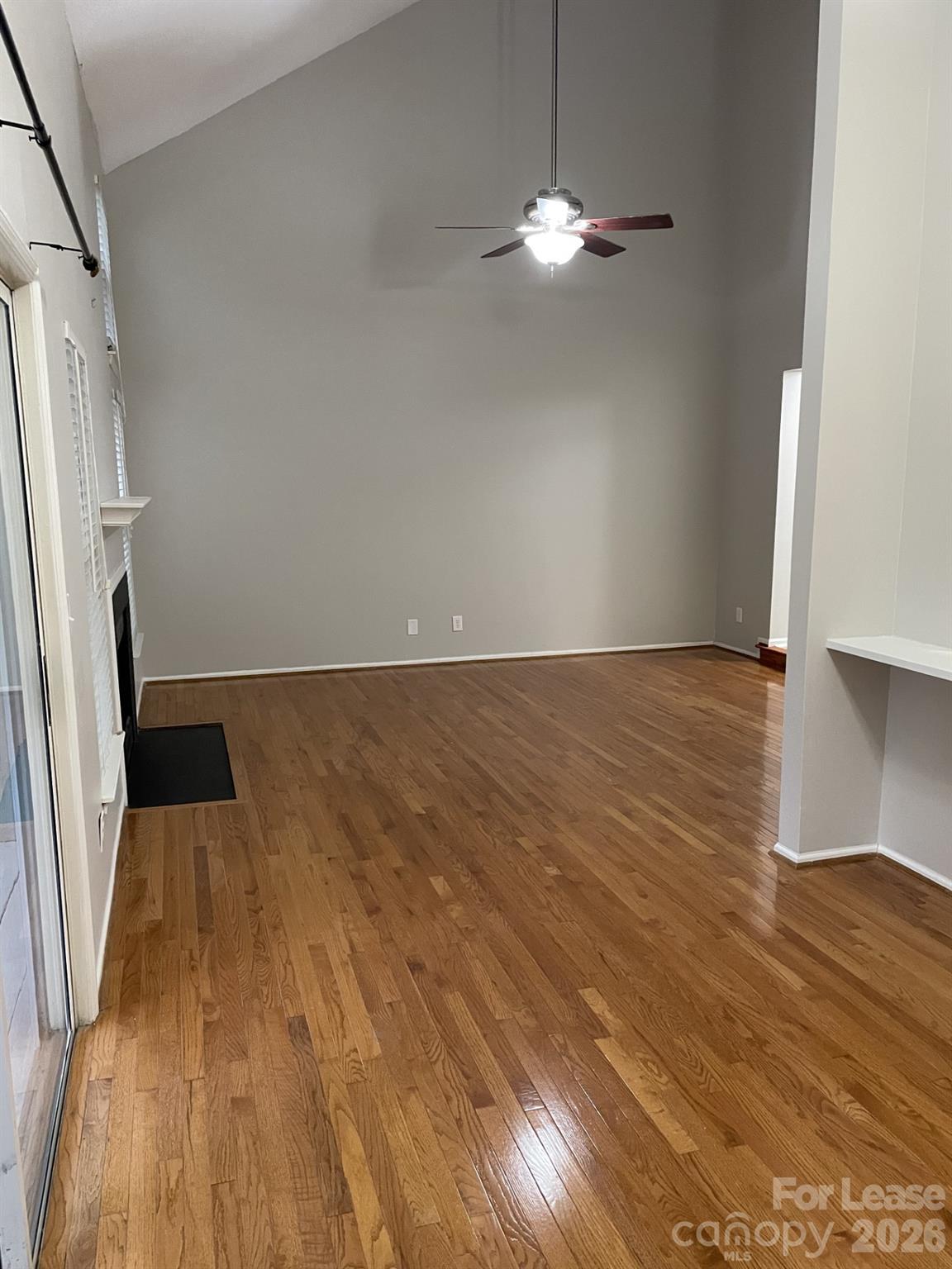 19831 Henderson Road, Unit E Cornelius, NC 28031 - Photo 10 of 27 an empty room with wooden floor and staircase