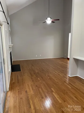 an empty room with wooden floor and staircase