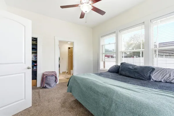 a bedroom with a bed and a large window