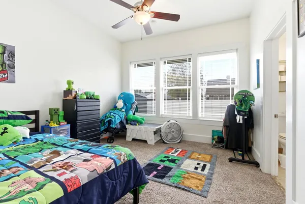 a bedroom with a bed potted plants on the table and chair