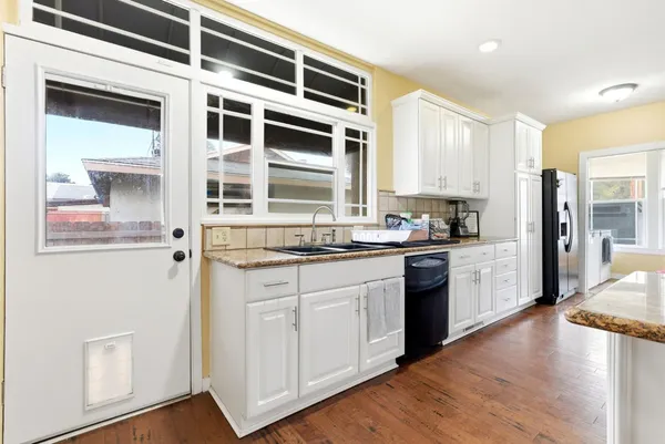 a kitchen with granite countertop a sink and a stove