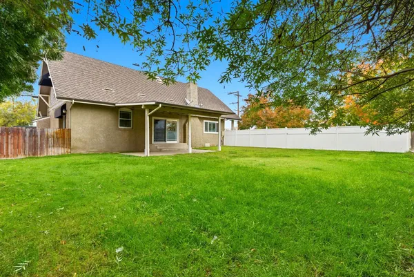 an aerial view of a house with a yard and large trees