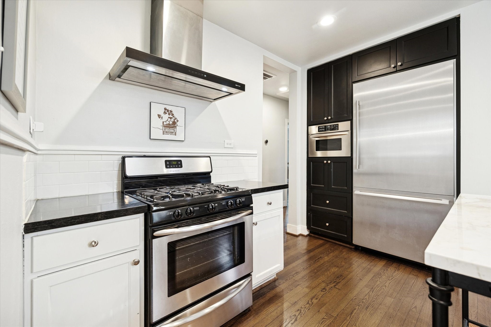 2109 Colquitt Street Houston, TX 77098 - Photo 13 of 28 Stainless steel appliances are paired with abundant cabinetry, blending classic style with modern convenience.
