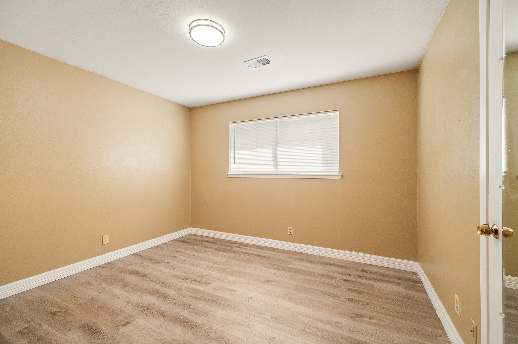 8314 Edgemoor Drive Houston, TX 77036 - Photo 23 of 34 an empty room with a wooden floor and a window