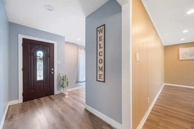 a view of a hallway with wooden floor and staircase