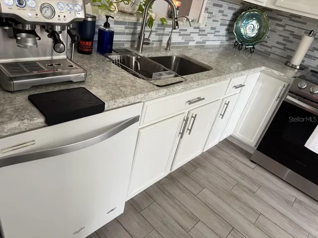 a kitchen with stainless steel appliances granite countertop a sink and a stove