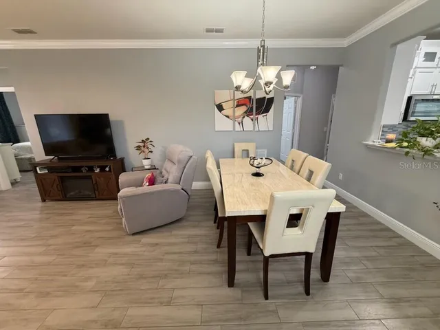 a dining room with furniture a chandelier and wooden floor