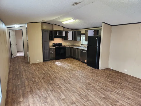 a kitchen with stainless steel appliances kitchen island granite countertop a refrigerator and a sink