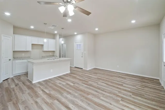 a view of kitchen with granite countertop cabinets and wooden floor