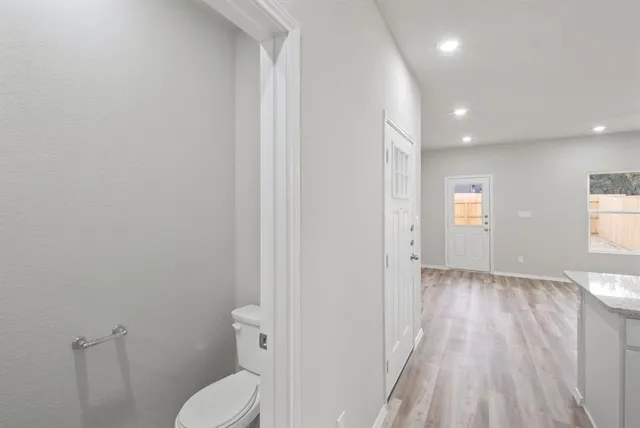 a bathroom with a toilet and a hardwood