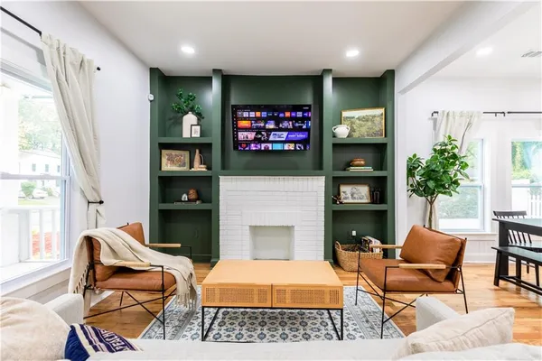 a living room with furniture a flat screen tv and a fireplace