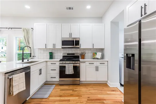 a kitchen with stainless steel appliances granite countertop a stove a sink and a refrigerator