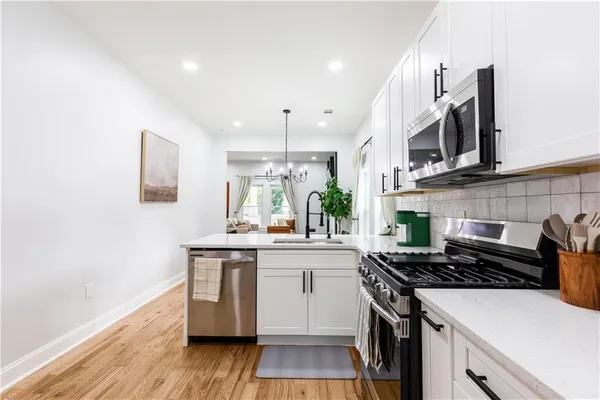 a kitchen with stainless steel appliances a sink a stove and cabinets