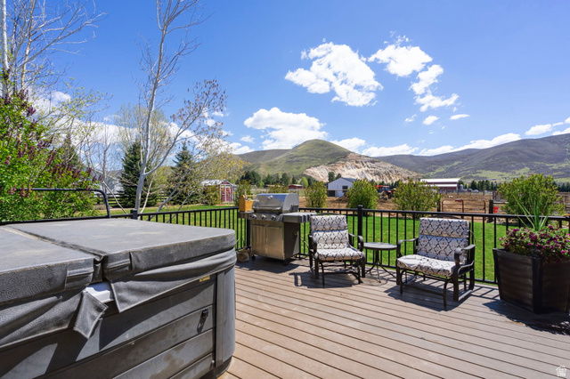 781 West 3000 South Heber City, UT 84032 - Photo 21 of 30 Deck with a hot tub, area for grilling, a mountain view, and a lawn